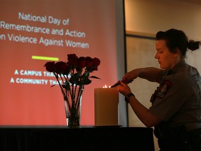 Jordyn Tanner with campus security lights a memorial candle at the University of Calgary on the National Day of Remembrance and Action on Violence Against Women on Wednesday December 6, 2017. Gavin Young/Postmedia