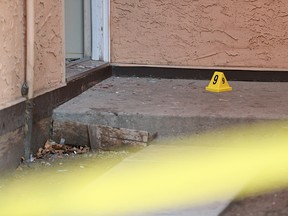 A crime scene marker is placed near broken glass and blood outside a unit in a Rundle condominium complex on Thursday December 7, 2017. The home on Rundlehorn Terrace N.E. was the scene of an early morning suspicious death.