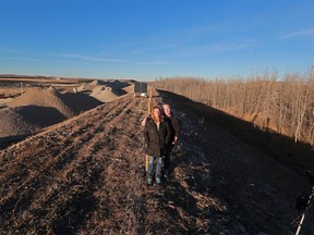 Mack and Lenore Kay stand near the gravel pit directly behind their home in West Springs on Monday December 11, 2017. Residents are frustrated dealing with regular coatings of dust and noise from the pit. Homes can be seen in the trees at right. Gavin Young/Postmedia