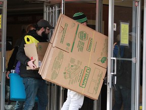 Residents and helpers take in cardboard boxes into Kensington Manor on 10 St SW in Calgary on Wednesday, December 6, 2017. Some residents were allowed in to remove items after the building was deemed a hazard by the City of Calgary due to structural concerns. Jim Wells/Postmedia