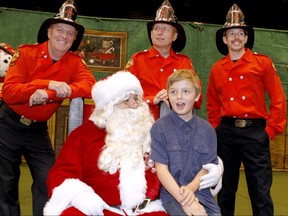 Cory Sanders, 10 yrs, joins Santa and firefighters during the annual Calgary Firefighters Annual Christmas Party held at the Corral arena Sunday, December 17, 2017. Jim Wells/Postmedia