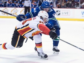 Calgary Flames left winger Johnny Gaudreau fights for control of the puck with Vancouver Canucks defenceman Troy Stecher on Dec. 17, 2017