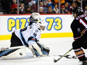 Kootenay Ice goalie Duncan McGovern (left) blocks a shot on net from Calgary Hitmen player Jakob Stukel in WHL action at the Scotiabank Saddledome in Calgary, on Sunday, December 17, 2017.