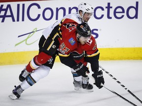 San Jose Sharks Marc-Edouard Vlasic checks Flames Sam Bennett during third period NHL hockey action in Calgary on Dec. 14, 2017.