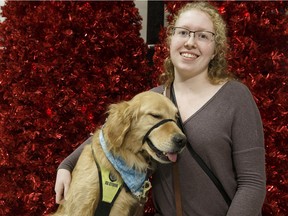 Paige Noelck poses for a photo with her psychiatric and cardiac alert service dog Earl as the government of Alberta announces five more qualified organizations to train, test and provide service dogs, at West Edmonton Mall in Edmonton on Tuesday, December 12, 2017