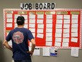 An unemployed truck driver checks out job listings at a mall in Sarnia, Ont.