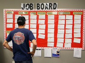 An unemployed truck driver checks out job listings at a mall in Sarnia, Ont.