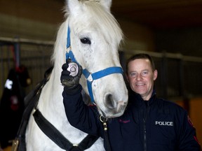Constable Rob MacLeod and Juno, who completed his training and earned his badge, pose for a photo at CPS stables in Calgary, on Thursday December 21, 2017. Leah Hennel/Postmedia Network