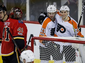 Philadelphia Flyers' Scott Laughton, centre, celebrates his goal with teammate Taylor Leier, right, as Calgary Flames goalie Mike Smith looks on during third period NHL hockey action in Calgary on Monday. Photo by Jeff McIntosh/THE CANADIAN PRESS.