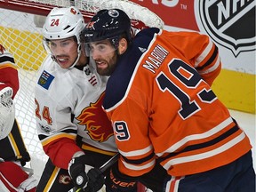 Edmonton Oilers forward Patrick Maroon (19) battles with Calgary Flames blueliner Travis Hamonic during the season opener of NHL action at Rogers Place in Edmonton, October 4, 2017.