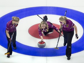 Skip Chelsea Carey, from Calgary, Alta. throws a rock as lead Laine Peters and second Jocelyn Peterman prepare to sweep during the Olympic curling trials Wednesday December 6, 2017 in Ottawa. THE CANADIAN PRESS/Adrian Wyld ORG XMIT: ajw110