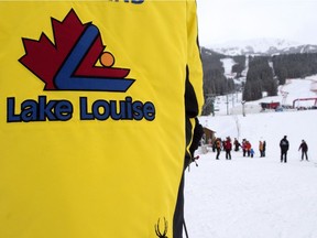 A Lake Louise guest host directs skiers off the mountain after a power failure shut down all operations prior to the women's World Cup downhill race in Lake Louise, Alta., on Saturday, Dec. 2, 2017.