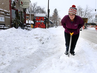 Hannah White shovels the snow from in front of her business after the first big snowfall of the season. Wednesday, December 20, 2017.