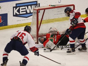 Hungarian National U18 goaltender Lajos Gonczi makes a sprawling save on a shot from Tisdale Trojans forward Mackenzie Carson with Trojans defenceman Carter Lake (9) coming in for the rebound followed by Hungarian defender Mate Seregely as the Tisdale Trojans play the Hungarian National U18 team during second period, round-robin action during the Mac's AAA Midget Hockey Tournament at the Max Bell Centre on Friday, Dec. 29, 2017 in Calgary. (Britton Ledingham/Postmedia Network)