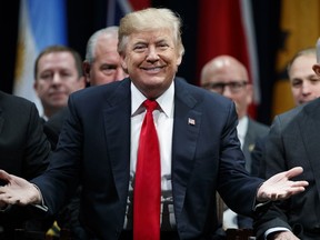 President Donald Trump gestures to the crowd at the FBI National Academy graduation ceremony, Friday, Dec. 15, 2017, in Quantico, Va.