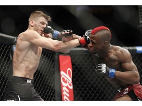 Marc Diakiese hits Dan Hooker in a lightweight mixed martial arts bout at UFC 219, Saturday, Dec. 30, 2017, in Las Vegas.