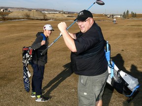 Dad, Justin Bugera with his son Jason were taking advantage of the warm December weather golfing at Fox Hollow Golf course which plans to stay open until the snow blows in Calgary on Sunday December 10, 2017. Darren Makowichuk/Postmedia