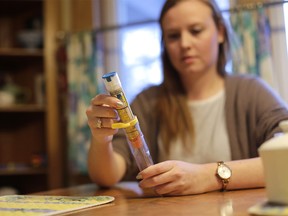 Kate Henderson, who has a peanut allergy, handles her EpiPen in her Ottawa home on Jan. 6, 2017. (David Kawai)