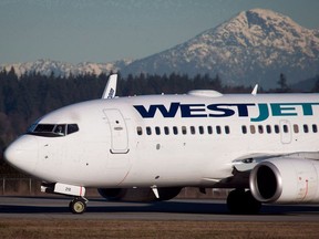 A pilot taxis a Westjet Boeing 737-700 plane to a gate after arriving at Vancouver International Airport in on February 3, 2014. WestJet is asking a B.C. Supreme Court today to throw out a proposed class-action lawsuit that accuses the company of failing to provide a harassment-free workplace for female employees.