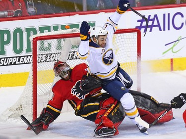 The Buffalo Sabres Nicholas Baptiste falls on Calgary Flames goaltender Mike Smith during NHL action at the Scotiabank Saddledome on Calgary on Monday January 22, 2018.