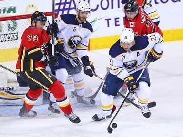 The Buffalo Sabres' Kyle Okposo works to clear the puck during NHL action against the Calgary Flames at the Scotiabank Saddledome on Calgary on Monday January 22, 2018.