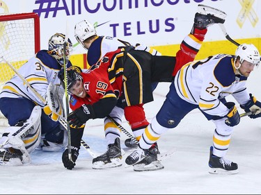 The Calgary Flames' Matthew Tkachuk fights for balance in front of Buffalo Sabres goaltender Chad Johnson during NHL action at the Scotiabank Saddledome on Calgary on Monday January 22, 2018.