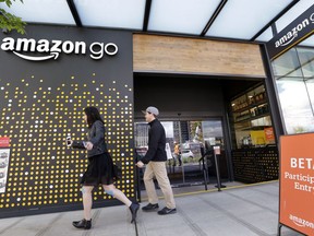 In this April 27, 2017, file photo, people walk past an Amazon Go store in Seattle. More than a year after it introduced the concept, Amazon is opening its artificial intelligence-powered Amazon Go store in downtown Seattle on Monday, Jan. 22, 2018.