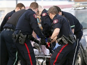 Calgary police take a male suspect into custody near 37 Street and Bow Trail S.W. on Saturday.