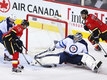 The Calgary Flames' Johnny Gaudreau comes close on this shot on Winnipeg Jets goaltender Connor Hellebuyck during NHL action at the Scotiabank Saddleome in Calgary on Saturday January 20, 2018.