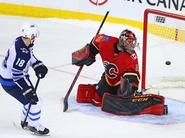 The Winnipeg Jets' Bryan Little scores on Calgary Flames goaltender Mike Smith during a shoot out in NHL action at the Scotiabank Saddleome in Calgary on Saturday January 20, 2018.