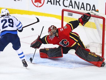 Calgary Flames goaltender Mike Smith stops this shot by Patrik Laine during a shoot out in NHL action at the Scotiabank Saddleome in Calgary on Saturday January 20, 2018.