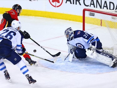 The Calgary Flames' Mark Jankowski reaches for a rebound after a shot on Winnipeg Jets goaltender Connor Hellebuyck during NHL at the Scotiabank Saddleome in Calgary on Saturday January 20, 2018.