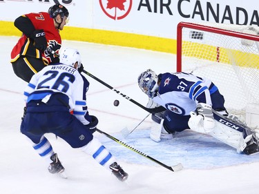 The Calgary Flames' Mark Jankowski reaches for a rebound after a shot on Winnipeg Jets goaltender Connor Hellebuyck during NHL at the Scotiabank Saddleome in Calgary on Saturday January 20, 2018.