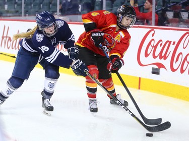 The Mount Royal University Cougars' Amy Tatum and the University of Calgary Dinos' Paige Michalenko figh for the puck during the Crowchild Classic at the Scotiabank Saddledome in Calgary on Thursday January 25, 2018.