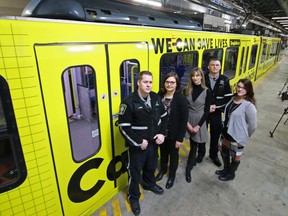 Associate Minister of Health Brandy Payne, second from left, stands with bylaw officers and relatives of overdose victims at the unveiling of a wrapped CTrain in Calgary on Monday January 28, 2018. The car is a part of a provincial opioid awareness campaign. Gavin Young/Postmedia