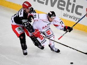 Mountfield's Oskars Cibulskis, left, fights for the puck with Team Canada's Cody Goloubef during the game between Team Canada and Mountfield HK at the Spengler Cup on Dec. 26, 2017