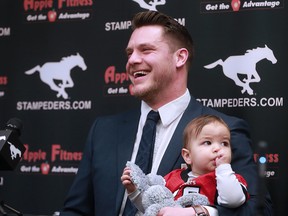 Calgary Stampeders linebacker Rob Cote holds his son Wynn as he announces his retirement at McMahon Stadium on Tuesday, Jan. 23, 2018.