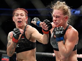 Cris “Cyborg” Justino, left, hits Holly Holm during a featherweight championship mixed martial arts bout at UFC 219, Saturday, Dec. 30, 2017, in Las Vegas. (AP Photo/John Locher)