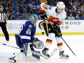Calgary Flames left wing Matthew Tkachuk (19) deflects the puck into Tampa Bay Lightning goalie Andrei Vasilevskiy (88), of Russia, during the first period of an NHL hockey game Thursday, Feb. 23, 2017, in Tampa.