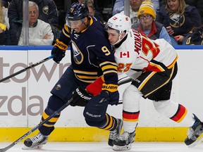 Buffalo Sabres forward Evander Kane (9) and Calgary Flames center Sean Monahan (23) battle for the puck during the first period of an NHL hockey game, Monday, Nov. 21, 2016, in Buffalo.