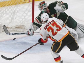 The Calgary Flames' Sean Monahan scores a goal on Minnesota Wild goalie Alex Stalock in the second period of an NHL hockey game Tuesday, Jan. 9, 2018, in St. Paul, Minn.