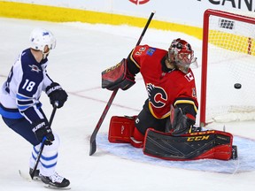The Winnipeg Jets' Bryan Little scores on Calgary Flames goaltender Mike Smith during a shoot-out in NHL action at the Scotiabank Saddleome in Calgary on Saturday January 20, 2018.