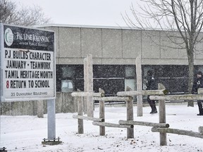 Two police officers walk around Pauline Johnson Junior Public School in Toronto on Jan. 15, 2018. The family of an 11-year-old Toronto girl has reportedly apologized for the "pain and anger" they caused, after the girl's claim that a man cut her hijab turned out not to be true.