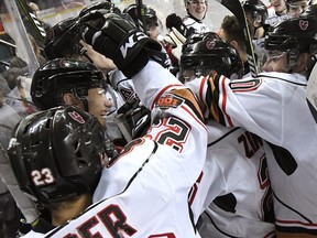 Conner Chaulk is mobbed by Calgary Hitmen teammates after scoring the overtime winner Sunday, Jan, 21, over the Raiders at the Saddledome.