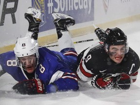 Canada's Dillon Dube, right, and the United States' Adam Fox collide during third period IIHF World Junior Championship preliminary outdoor game action at New Era Field in Orchard Park, N.Y., Friday, December 29, 2017.