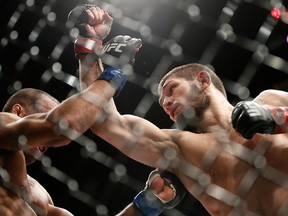 Khabib Nurmagomedov, right, takes a swing at Edson Barboza during a lightweight mixed martial arts bout at UFC 219, Saturday, Dec. 30, 2017, in Las Vegas. (AP Photo/John Locher)