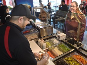 Labour Minister Christina Gray watches worker Shawn Mohammed make her donair after speaking with co-owner Adil Asim of Prime Time Donair & Kabab, to discuss recent changes to Albertaís employment standards in downtown Edmonton, January 23, 2018. Ed Kaiser/Postmedia