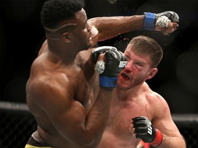 Stipe Miocic (right) lands a right hand against Francis Ngannou during a heavyweight championship mixed martial arts bout at UFC 220, early Sunday, Jan. 21, 2018, in Boston. Miocic retained his title via unanimous decision.