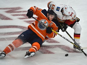 Edmonton Oilers Connor McDavid (97) gets taken down by Calgary Flames Johnny Gaudreau during the season opener of NHL action at Rogers Place in Edmonton, October 4, 2017. Ed Kaiser/Postmedia (Edmonton Journal story by Jim Matheson)