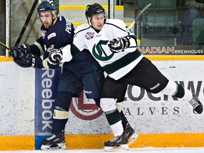 Sherwood Park's Tanner Laderoute, in white, hits Spruce Grove's Macklin Pichonsky during AJHL playoff action on March 22, 2015